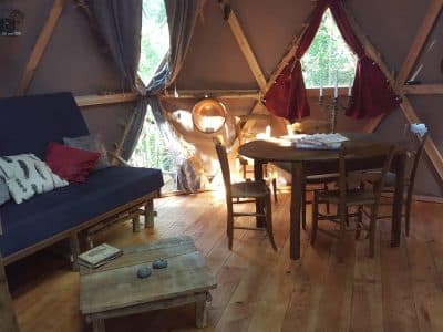 Hébergement insolite en yourte à Limousin, intérieur chaleureux avec bois et lumière naturelle.