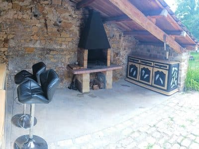 Hébergement insolite en Champagne-Ardenne : espace extérieur avec barbecue et bar en bois.
