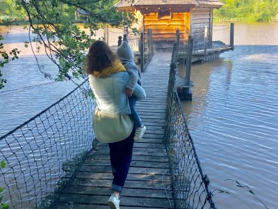 Cabane sur pilotis au bord de leau, accessible par un pont en bois. Moment paisible en famille.