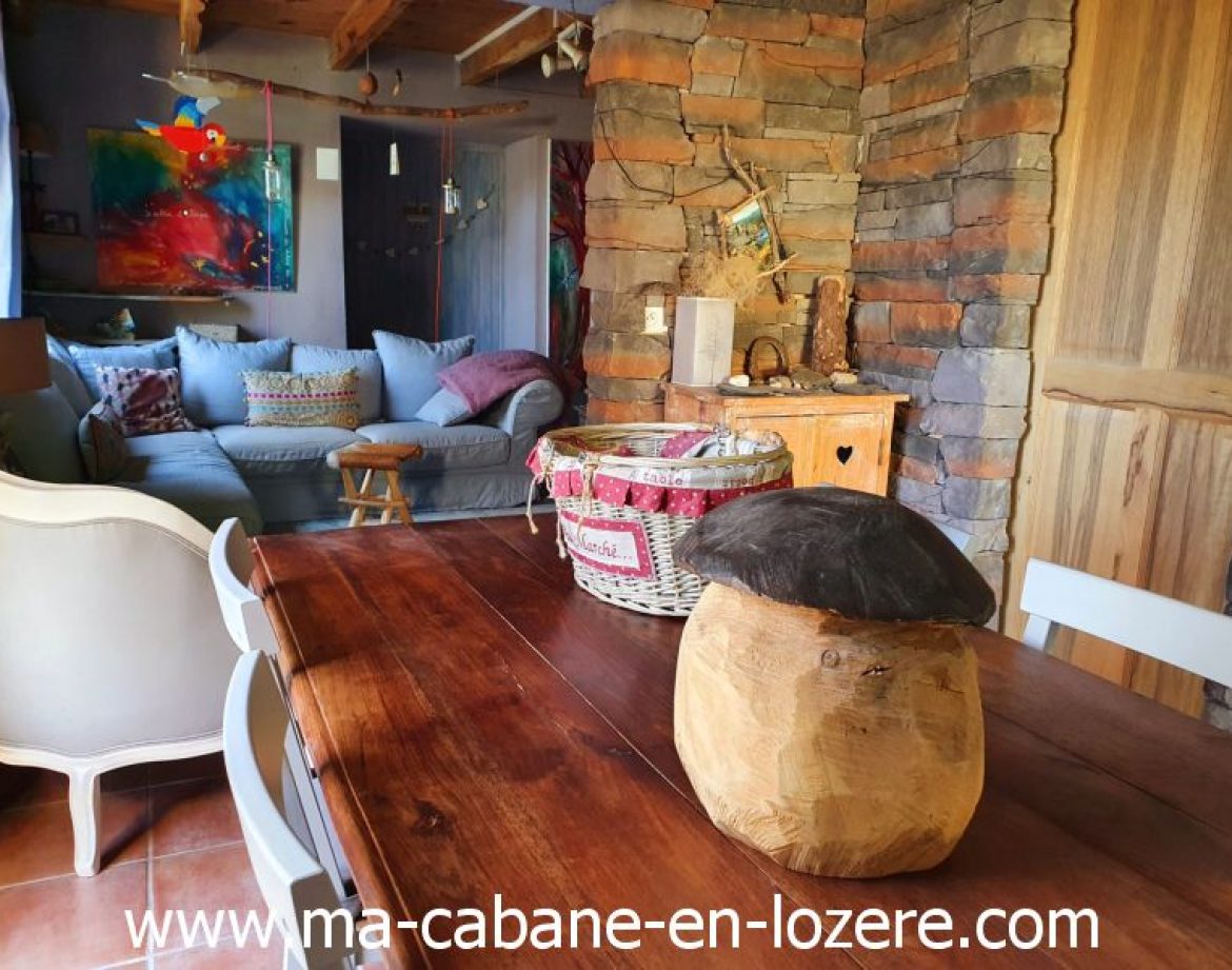 Hébergement insolite en cabane, intérieur chaleureux avec un mobilier en bois.