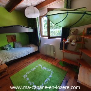 Chambre dhôte originale avec lit superposé et décor coloré, idéale pour enfants.