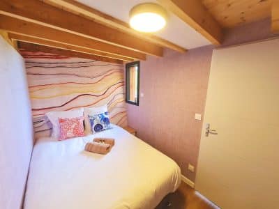 Chambre cocooning en bois avec murs colorés, idéale pour un séjour en Bourgogne-Franche-Comté.