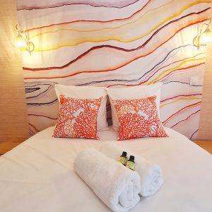 Chambre dhôtes originale en Bourgogne-Franche-Comté avec un mur décoratif coloré.