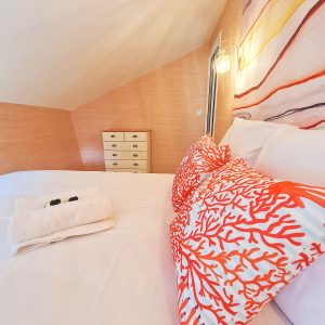 Chambre dhôtes moderne en Bourgogne, avec coussins colorés et ambiance chaleureuse.