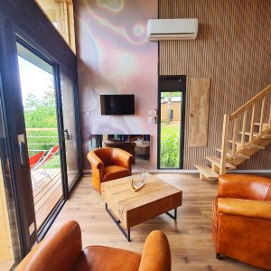 Hébergement insolite en Bourgogne-Franche-Comté, salon lumineux avec fauteuils en cuir.