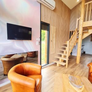 Hébergement insolite en Bourgogne-Franche-Comté, avec un intérieur en bois et un escalier moderne.