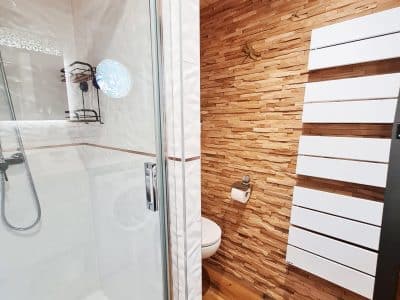 Salle de bain moderne dun hébergement insolite en Bourgogne-Franche-Comté, avec douche vitrée.