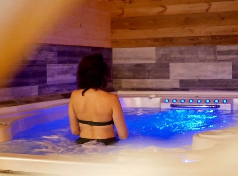 Hébergement de luxe avec jacuzzi, ambiance relaxante et éclairage bleu apaisant.