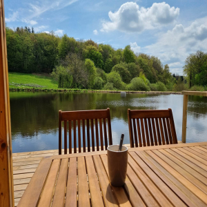 Cabane flottante en Bourgogne, vue sur un lac entouré de verdure.