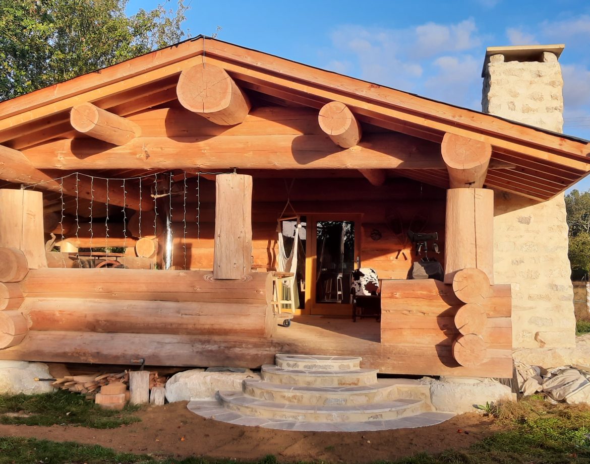 Cabane en bois à Champagne-Ardennes, avec un toit en pente et des rondins apparents.