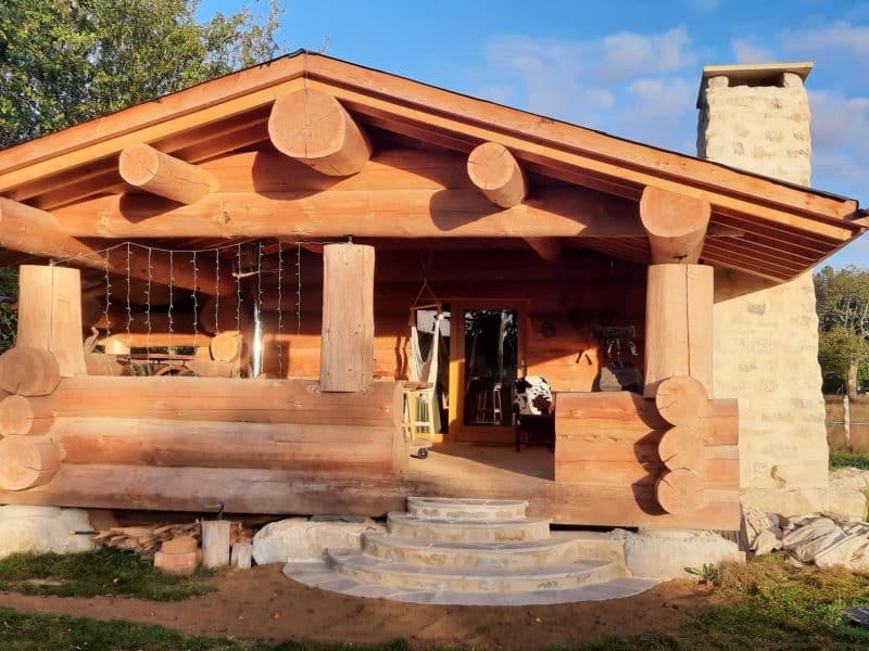 Cabane en bois à Champagne-Ardennes, avec un toit en pente et des rondins apparents.
