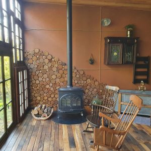 Hébergement insolite en Nouvelle-Aquitaine : chalet en bois avec poêle à bois et vue sur la nature.