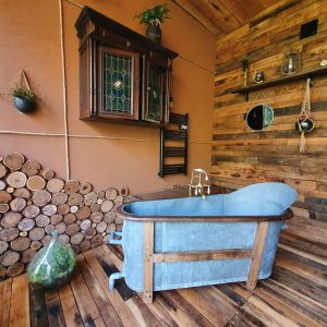 Hébergement insolite en Nouvelle-Aquitaine : baignoire vintage dans un décor en bois chaleureux.