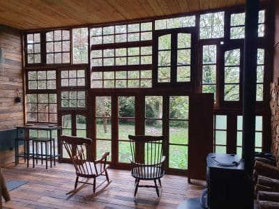 Hébergement insolite en Nouvelle-Aquitaine, avec de grandes fenêtres et un intérieur en bois.