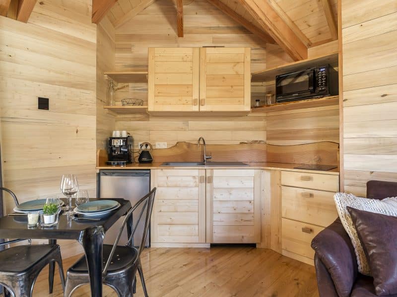 Chalet en bois chaleureux avec cuisine équipée et coin repas convivial.