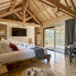 Chalet en bois moderne avec lit douillet et vue sur la nature. Parfait pour un séjour relaxant.