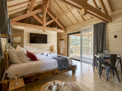 Chalet en bois moderne avec lit douillet et vue sur la nature. Parfait pour un séjour relaxant.