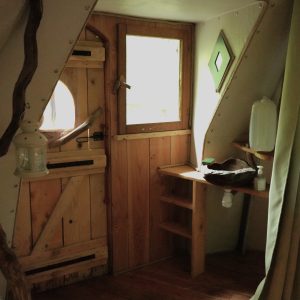 Cabane en bois à Bourgogne-Franche-Comté, avec porte originale et décor naturel.