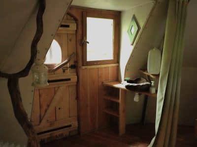 Cabane en bois à Bourgogne-Franche-Comté, avec porte originale et décor naturel.
