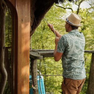 Cabane perchée en Bourgogne-Franche-Comté, vue sur la nature verdoyante.