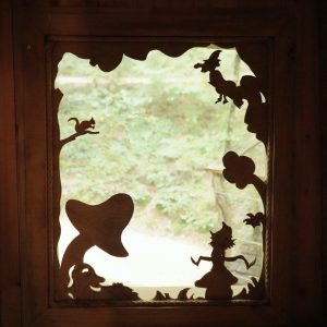 Cabane perchée en Bourgogne-Franche-Comté avec fenêtre en bois sculpté.