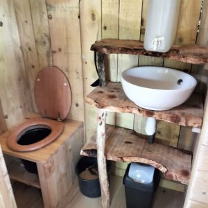 Hébergement insolite en Bourgogne-Franche-Comté avec toilettes en bois et lavabo en pierre.