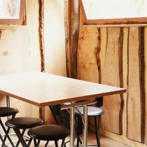 Hébergement insolite en bois en Bourgogne-Franche-Comté, avec table moderne et murs naturels.