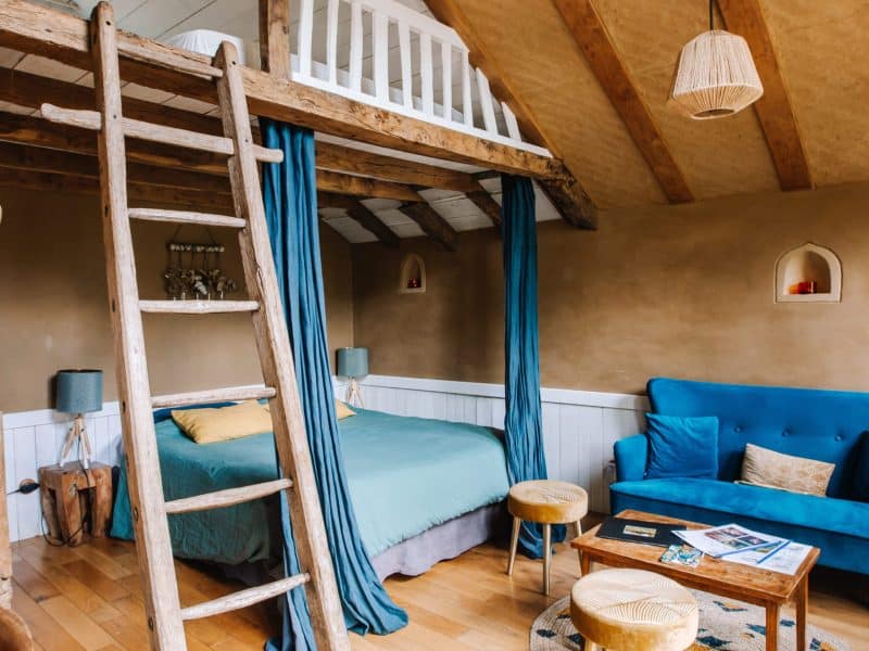 Chalet cosy avec mezzanine, décor chaleureux et touches de bleu apaisant.