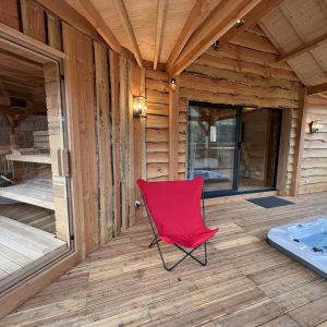 Hébergement insolite en bois avec sauna et jacuzzi, ambiance chaleureuse et naturelle.