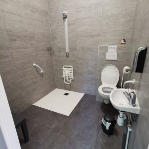 Salle de bain accessible dun hébergement insolite en Auvergne-Rhône-Alpes, moderne et spacieuse.