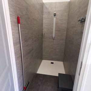 Douche spacieuse dun hébergement insolite en Auvergne-Rhône-Alpes, murs en carrelage moderne.