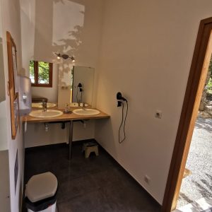 Salle de bain moderne dun hébergement insolite en Auvergne-Rhône-Alpes, lumineuse et spacieuse.