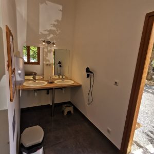 Salle de bain moderne dun hébergement insolite en Auvergne-Rhône-Alpes, lumineuse et spacieuse.