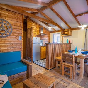 Cabane en bois à Aquitaine, intérieur chaleureux avec cuisine et mobilier en bois.