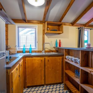 Hébergement insolite en Aquitaine : cuisine en bois avec étagères et décor coloré.
