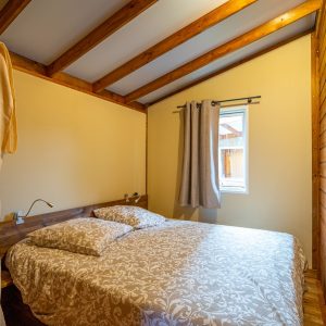 Chalet en bois cosy en Aquitaine, avec lit double et lumière naturelle.