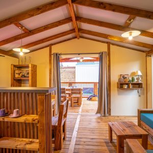 Hébergement insolite en Aquitaine : chalet en bois avec terrasse ensoleillée.