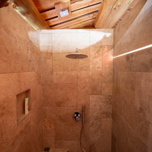 Douche en pierre dans un hébergement insolite à Champagne-Ardenne, ambiance naturelle.