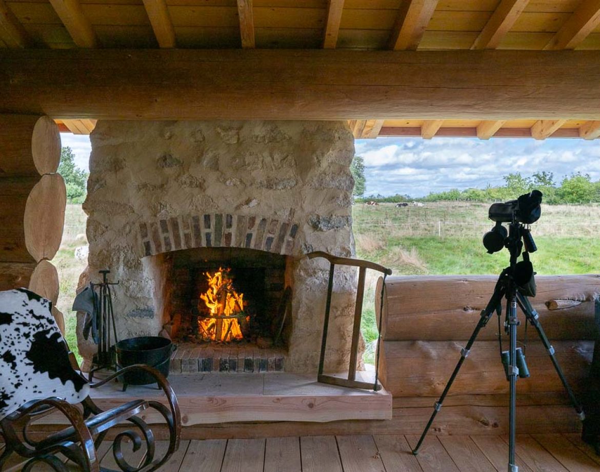 Cabane en bois avec cheminée, offrant une vue sur la nature en Champagne-Ardenne.