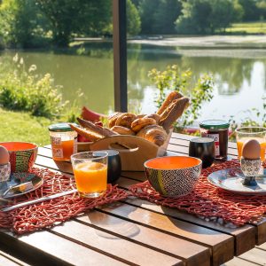 Hébergement insolite en Aquitaine : terrasse avec vue sur le lac, petit-déjeuner gourmand.