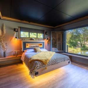 Chalet moderne avec vue sur la nature, lit douillet et ambiance chaleureuse.