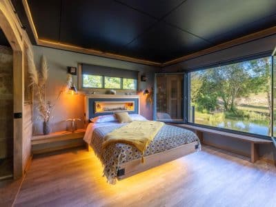 Chalet moderne avec vue sur la nature, lit douillet et ambiance chaleureuse.