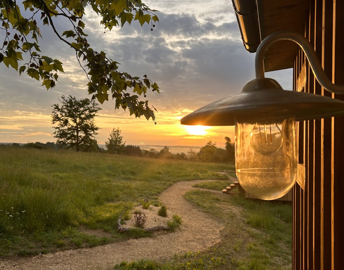Hébergement insolite en Aquitaine : cabane en bois avec vue sur le coucher de soleil.