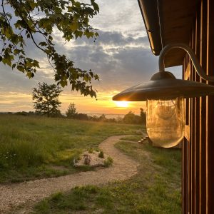 Hébergement insolite en Aquitaine : cabane en bois avec vue sur le coucher de soleil.