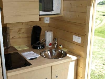 Hébergement insolite en Midi-Pyrénées : cuisine en bois moderne avec vue sur la nature.
