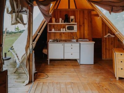 Tente lodge spacieuse en Midi-Pyrénées, avec kitchenette en bois et ambiance chaleureuse.