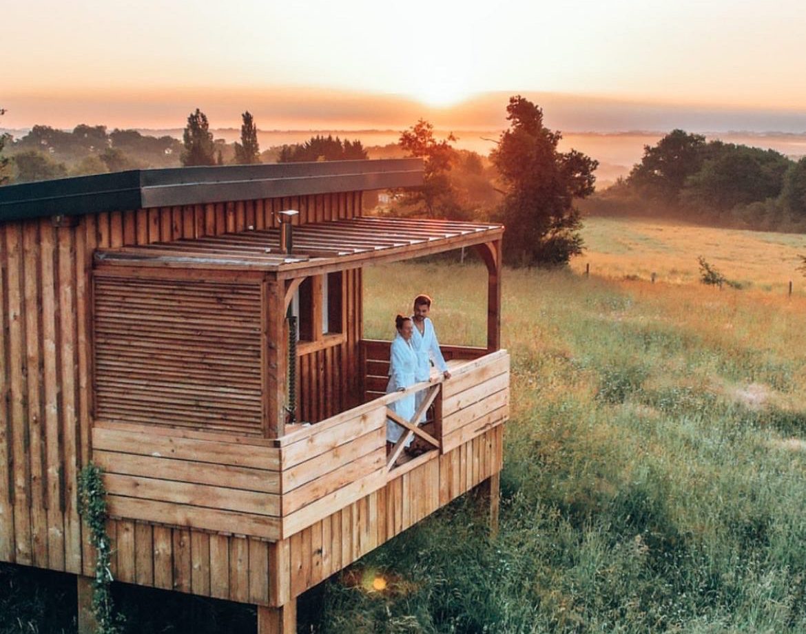 Cabane en bois sur pilotis avec vue panoramique sur le coucher de soleil en Aquitaine.