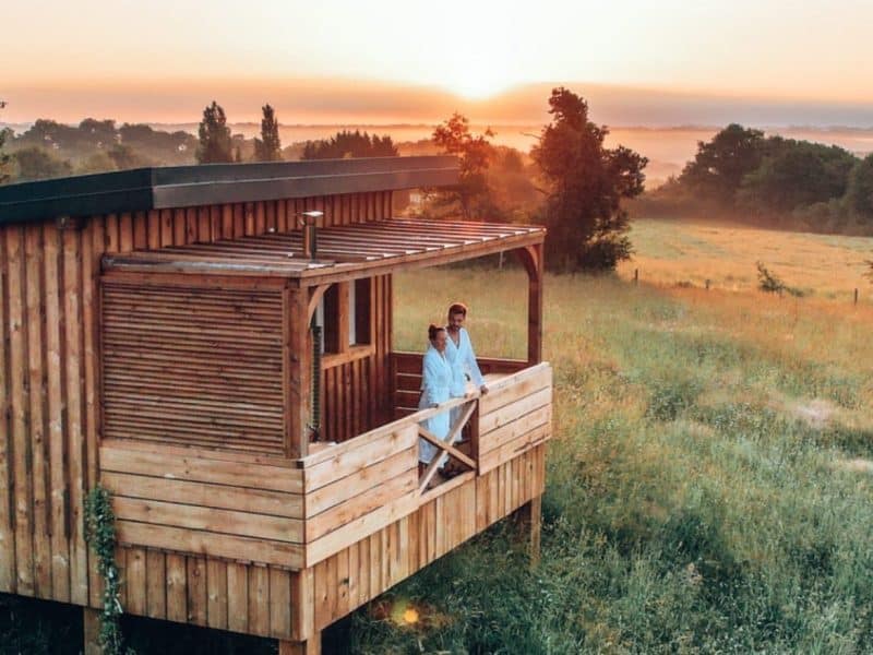 Cabane en bois sur pilotis avec vue panoramique sur le coucher de soleil en Aquitaine.