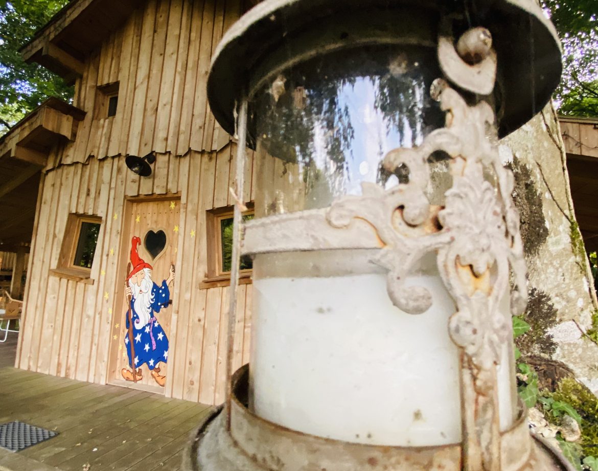 Cabane en bois en Bretagne, ornée dune lanterne vintage et dune porte colorée.