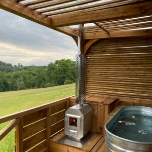 Hébergement insolite en Aquitaine : cabane en bois avec baignoire et poêle à bois.